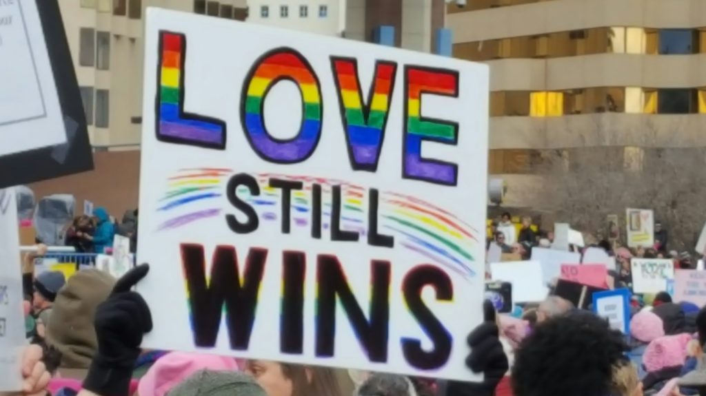 Protest sign reading "Love Still Wins"